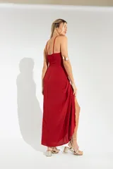 Vestido largo color naranja, con escote halter cruzado y falda tipo pareo con tajo lateral. Confeccionado en tela crepé con caída fluida.