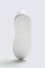 Zapatillas urbanas de cordones, color blanco, con parte superior lisa y suela con volumen.