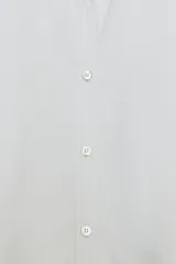 Camisa de popelín color rosa pálido, con cuello solapa, escote pico y manga larga terminada en puño. Cierre frontal con botones.