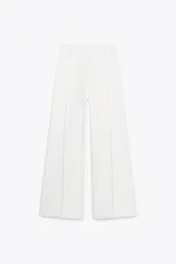 Jeans de tiro alto, pierna ancha y largo al tobillo, en denim celeste claro con efecto lavado. Presenta costura marcada en el centro de cada pierna y cierre frontal con cremallera y botón.