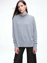 Sweater de cuello polera con hombros caídos y diseño de calce holgado. Presenta terminaciones acanaladas en puños y ruedo, confeccionado en tejido de punto suave.