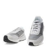 Championes New Balance modelo U370, de estilo retro y perfil bajo. Presentan un diseño en tonos grises, combinando paneles de malla textil con refuerzos de gamuza. Incluyen el logo característico en los laterales, cierre mediante cordones y una suela de goma con entresuela blanca.