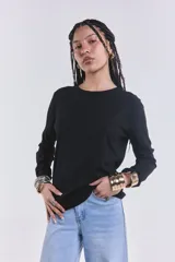Remera básica de manga larga en color negro, con textura acanalada y cuello redondo.