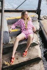 Camisa a rayas verticales rojas y blancas, de corte holgado y manga larga.