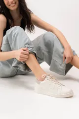 Championes de cuero color blanco con detalle de corona en animal print y talón verde. Cuentan con suela de caucho, lengüeta de gamuza y forro textil, con cierre mediante cordones al tono.