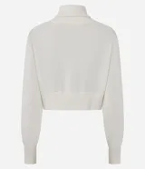 Campera cropped de tricot color blanco off-white, confeccionada en algodón con textura acanalada. Presenta cuello amplio con cierre metálico frontal, mangas largas con puños acanalados y cintura marcada con banda ancha.
