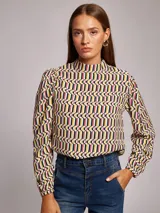 Blusa de viscosa con estampado geométrico multicolor, cuello subido y manga larga abullonada con frunces en los hombros.