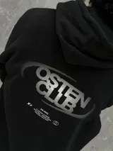 Canguro negro con capucha ajustable con cordones, bolsillo tipo canguro y logo "Osten Club" estampado en el pecho. Corte oversize.