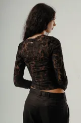 Top de manga larga ajustado, color negro, confeccionado en tejido de encaje con patrón floral.