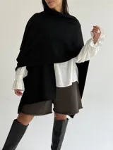 Ruana de tejido de punto trenzado en color crudo, con diseño abierto, corte holgado y mangas amplias tipo kimono.