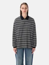 Remera polo de manga larga con diseño de rayas horizontales en tonos grises, blancos y negros. Presenta cuello clásico y puños en color negro sólido, tapeta con botones y logo bordado en el pecho.