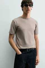 Camiseta de corte ajustado confeccionada en tejido de algodón con elasticidad, cuello redondo y manga corta.