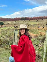 Capa roja de tejido de punto en lana con apliques en cuero y bordados.