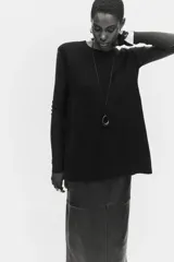 Chaleco de punto fino con lana, de corte holgado, cuello redondo y aberturas laterales pronunciadas. Presenta remates acanalados en el cuello, las sisas y el bajo.