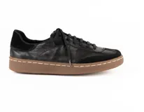 Zapatilla urbana de cuero vacuno color negro, con diseño de paneles en cuero liso y gamuza. Presenta suela de goma color suela con costura vista y cordones al tono.