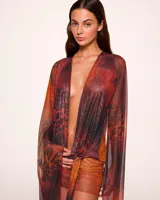 Minivestido cruzado con estampado animal print en tonos naranja, marrón y negro. Tiene escote en V pronunciado, mangas largas acampanadas y falda ajustada.