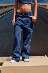 Jean de tiro bajo y corte oversize, confeccionado en denim azul con grabado láser de monograma en patrón de rombos. Presenta avíos metálicos y diseño de pierna ancha.