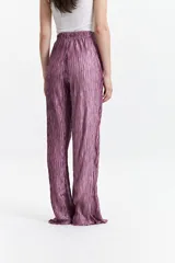 Pantalón de poliéster color lila con efecto metalizado y textura corrugada.