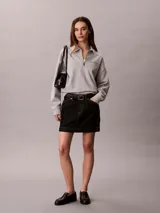 Buzo gris melange de french terry, con cuello tipo polo de media cremallera y manga larga. Presenta el logo de Calvin Klein bordado en el pecho.