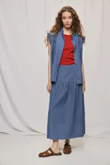 Falda midi de denim color beige, con diseño de volados y caída fluida.