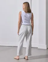 Pantalón de lino color beige con rayas verticales blancas, pretina elastizada con cordón ajustable, bolsillos laterales y ruedo con botamanga.