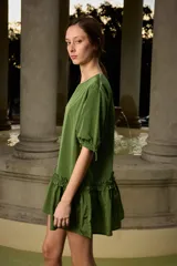 Vestido corto azul marino de corte suelto y silueta evasé, con cuello redondo, mangas cortas con regulador ajustable y detalle de volado fruncido en la parte inferior.