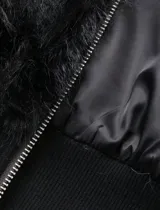 Campera de piel sintética en tono beige, con diseño de cuello alto y cierre frontal completo. Presenta una base de tejido liso en la parte inferior y puños ajustados.