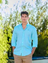 Camisa celeste de lino de manga larga con cuello camisero y cierre frontal de botones.