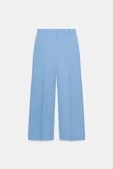 Pantalón de tiro medio con corte recto, confeccionado en mezcla de algodón. Presenta cintura con trabillas, bolsillos laterales ocultos en costura, raya planchada en el delantero y cierre frontal con cremallera, botón y ganchos metálicos.