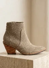 Bota corta de cuero vacuno en tono beige, con diseño de caña media y costuras decorativas visibles. Presenta un taco cuadrado de madera de 7 cm y suela de caucho antideslizante.