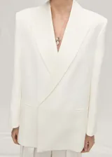 Blazer de corte recto y estilo sastre, color blanco, con cuello de solapa, cierre frontal de botón oculto y bolsillos laterales de ribete.