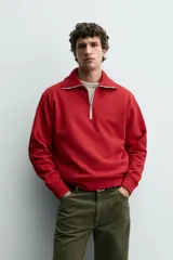 Sudadera de corte regular fit color rojo, con cuello subido y cierre frontal de cremallera. Presenta mangas largas y acabados en rib en puños y ruedo.