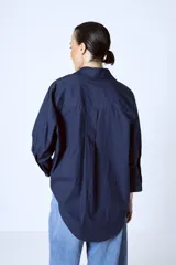 Camisa azul marino de corte holgado, con cuello clásico, cierre frontal con botones y mangas 3/4.