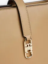 Cartera de hombro rectangular de color beige, confeccionada en poliuretano, con correa ajustable y cierre frontal mediante una tira con herraje metálico dorado con el logo de la marca.