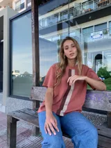 Buzo de hilo color ladrillo con rayas verticales en beige y marrón.