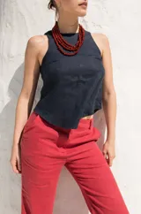 Top sin mangas de lino, con cuello redondo y cierre posterior mediante tres lazos. Diseño minimalista y versátil.