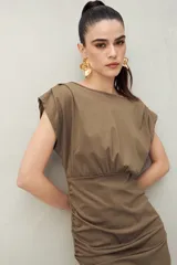 Vestido corto color verde militar, con escote bote, mangas cortas con hombreras y frunces laterales. Presenta escote en V en la espalda.