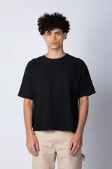 Remera de corte boxy y holgado, confeccionada en algodón pesado, con cuello redondo y diseño liso.