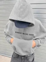 Canguro de felpa gris melange con capucha, manga larga y estampa trasera de estilo rockero con tipografía y calavera.