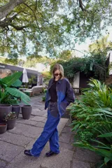 Pantalón de jean azul con parches en denim negro y azul oscuro.