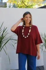 Sweater de punto color bordó, con cuello redondo, manga corta amplia y diseño holgado.