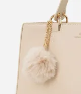 Cartera satchel mediana color beige, con cierre de cremallera, correa de mano y bretel largo desmontable. Incluye un llavero de pompón de piel sintética.