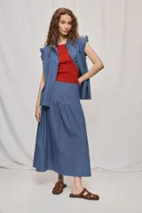 Falda midi de denim azul, con diseño de volados y caída fluida.