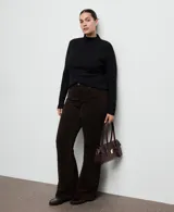 Pantalón de jean marrón oscuro, de tiro medio con diseño de corte recto y acabado ligeramente acampanado.