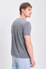 Camiseta gris de manga corta con estampado de los Avengers. El modelo usa talle L.