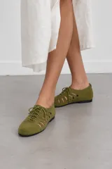 Zapatos planos de gamuza verde militar estilo oxfords abiertos, con cordones frontales y aberturas laterales.
