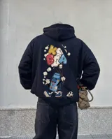 Buzo canguro con capucha color negro, de corte regular y felpa interior. Presenta un estampado gráfico en la espalda que representa un termo antropomórfico sosteniendo globos con letras.
