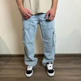Pantalón jean cargo gris con efecto lavado, corte recto y bolsillos laterales.