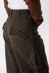 Jean de corte baggy con pierna recta y ancha, color verde oscuro con efecto lavado. Presenta bolsillos cargo laterales, costuras reforzadas y detalle de bordado del isologo en la parte trasera.