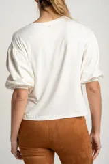 Remera blanca de manga corta abullonada con textura de puntos en relieve, escote redondo y calce holgado.